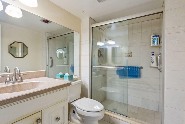 full bath with a stall shower, vanity, and toilet