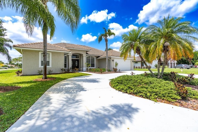 2904 SW Sutton Pl, Palm City, FL 34990 - mediterranean / spanish home featuring curved driveway, stucco siding, an attached garage, a front lawn, and a tile roof