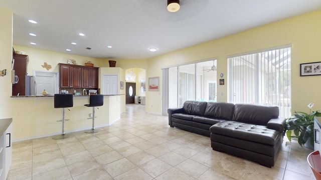 2904 SW Sutton Pl, Palm City, FL 34990 - living room featuring arched walkways, recessed lighting, ceiling fan, light tile patterned flooring, and baseboards