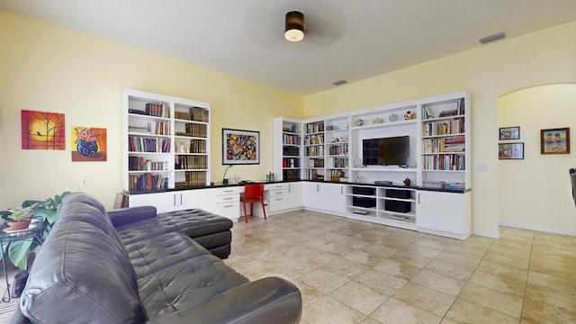2904 SW Sutton Pl, Palm City, FL 34990 - living area with arched walkways, a ceiling fan, baseboards, and built in features