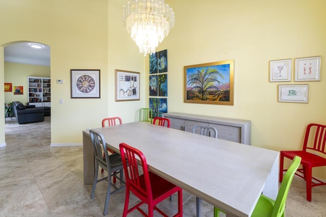 2904 SW Sutton Pl, Palm City, FL 34990 - dining space featuring arched walkways, baseboards, a chandelier, and a high ceiling