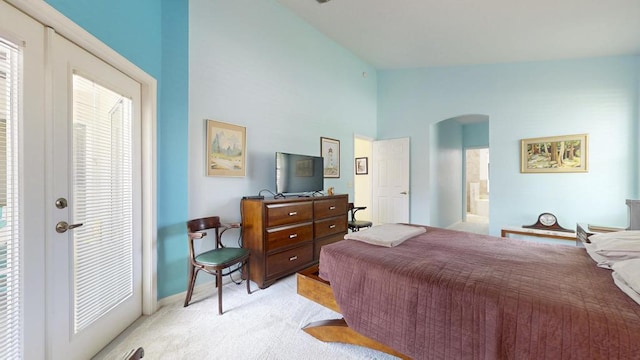 2904 SW Sutton Pl, Palm City, FL 34990 - bedroom featuring arched walkways, multiple windows, light carpet, lofted ceiling, and baseboards