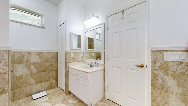 2904 SW Sutton Pl, Palm City, FL 34990 - bathroom with vanity, tile walls, tile patterned flooring, and wainscoting