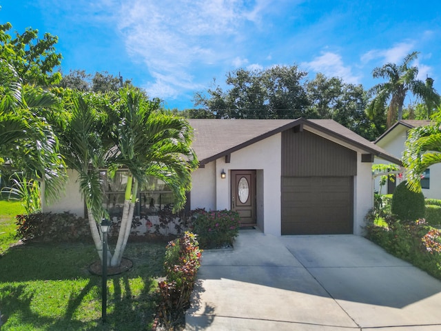 view of front of house with driveway, an attached garage, stucco siding, a shingled roof, and a front yard