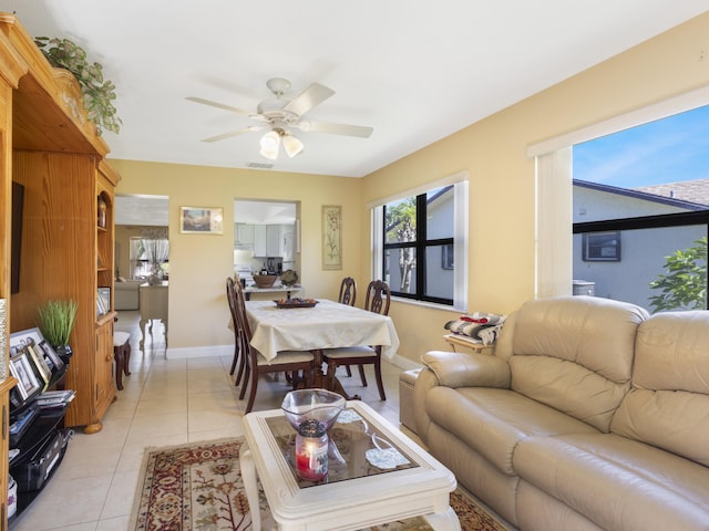 living room featuring ceiling fan, light tile patterned flooring, and baseboards
