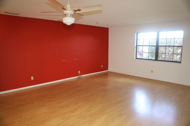 unfurnished room with light wood-type flooring, ceiling fan, and baseboards