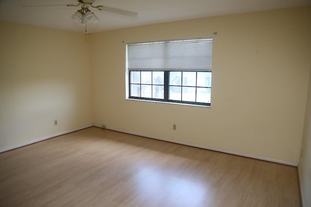 empty room featuring wood finished floors, ceiling fan, and baseboards