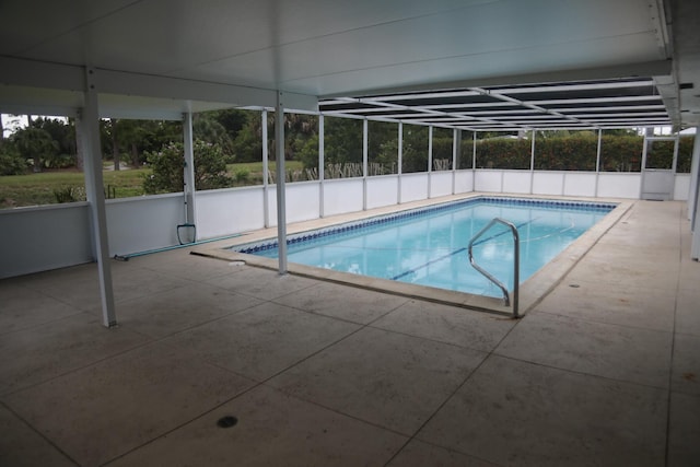 view of swimming pool with glass enclosure and a patio