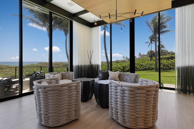 sunroom / solarium featuring a wall of windows, healthy amount of natural light, and wood finished floors