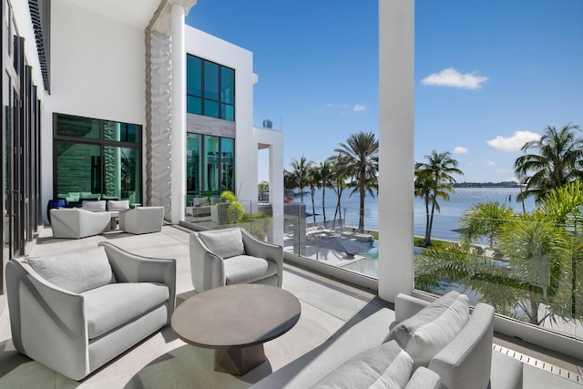 view of patio featuring a water view, outdoor lounge area, and a balcony