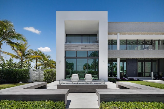 rear view of property featuring an outdoor fire pit