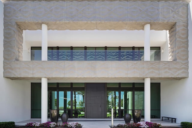 rear view of house featuring a balcony and stucco siding