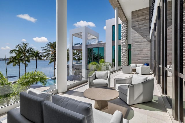 view of patio / terrace with an outdoor hangout area, a balcony, and a water view