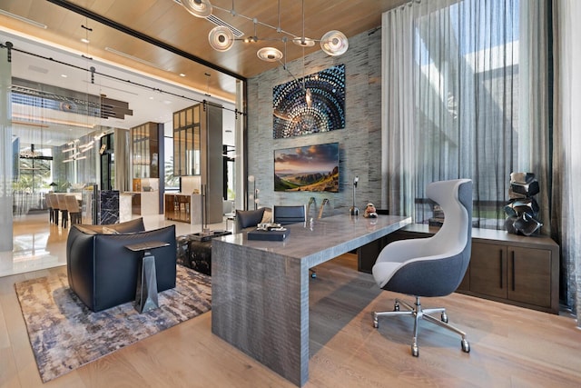 home office with wooden ceiling, wood finished floors, and a high ceiling