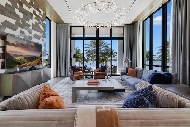 living room with a chandelier, expansive windows, plenty of natural light, and wood finished floors