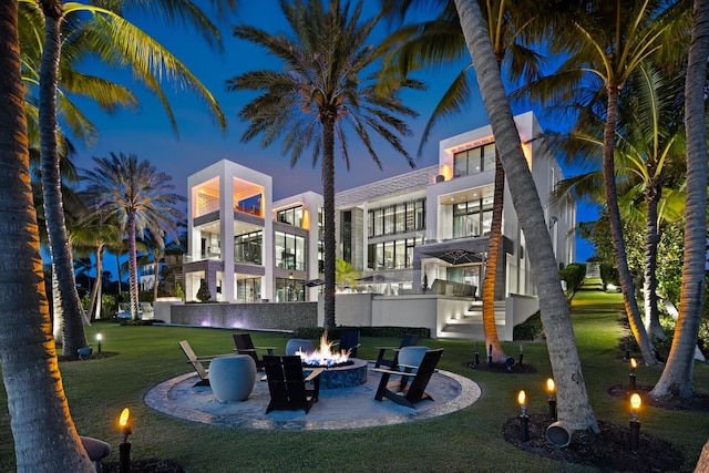 back of house with a fire pit, a lawn, a balcony, a patio, and stairway
