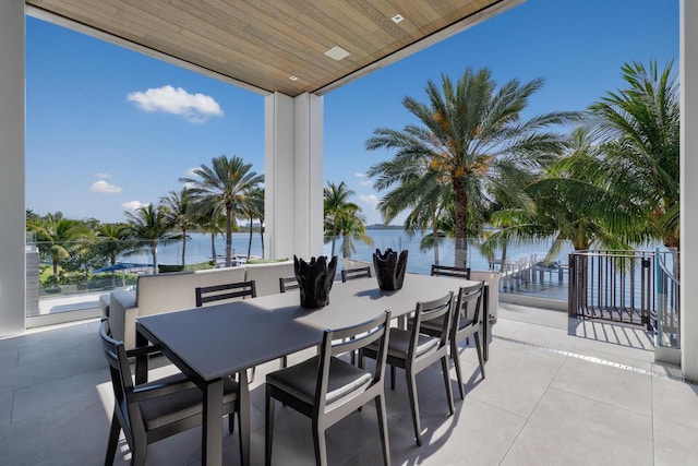 view of patio with a water view and outdoor dining space