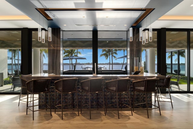 indoor dry bar with wood finished floors and healthy amount of natural light