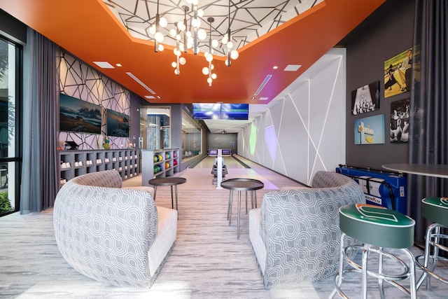 playroom with a chandelier and a bowling alley