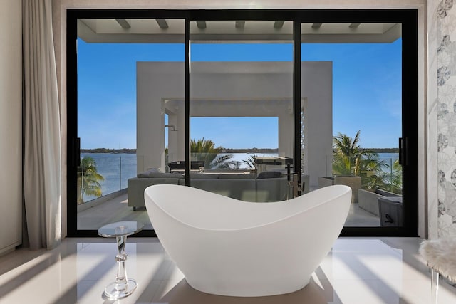 full bathroom with a freestanding bath and a water view