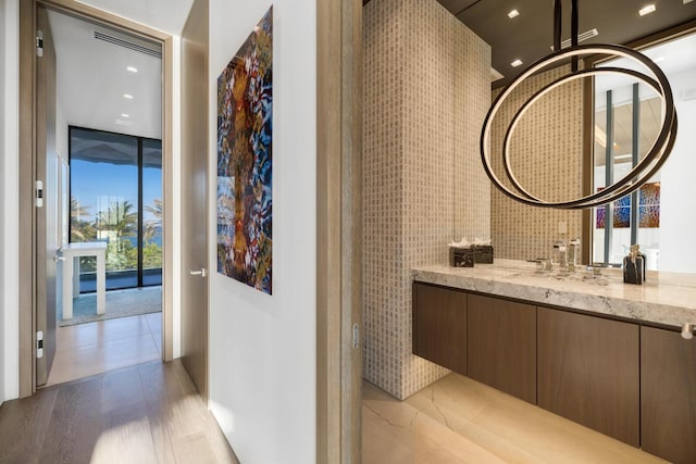 bathroom featuring vanity, wood finished floors, recessed lighting, and floor to ceiling windows