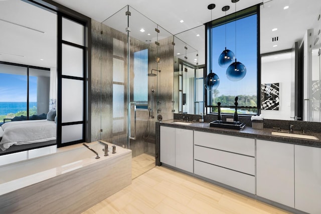 bathroom with a stall shower, double vanity, healthy amount of natural light, floor to ceiling windows, and ensuite bathroom