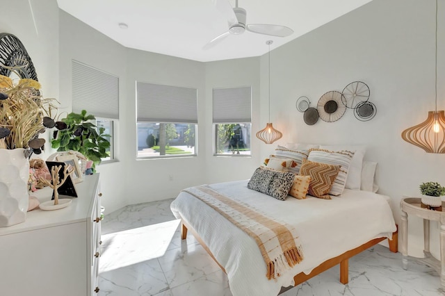 bedroom with light marble finish floors and ceiling fan