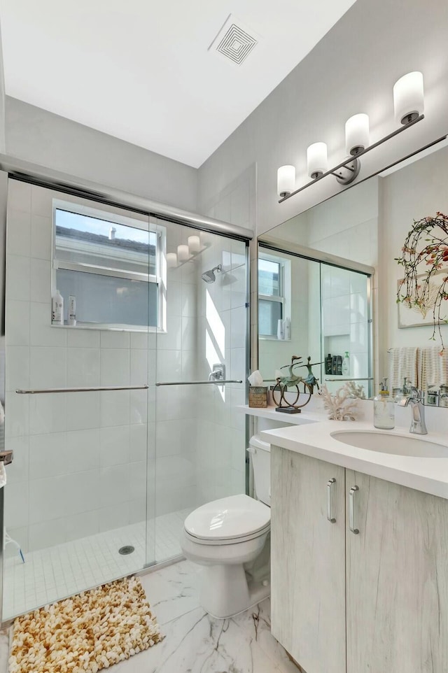 bathroom featuring toilet, a shower stall, marble finish flooring, and vanity