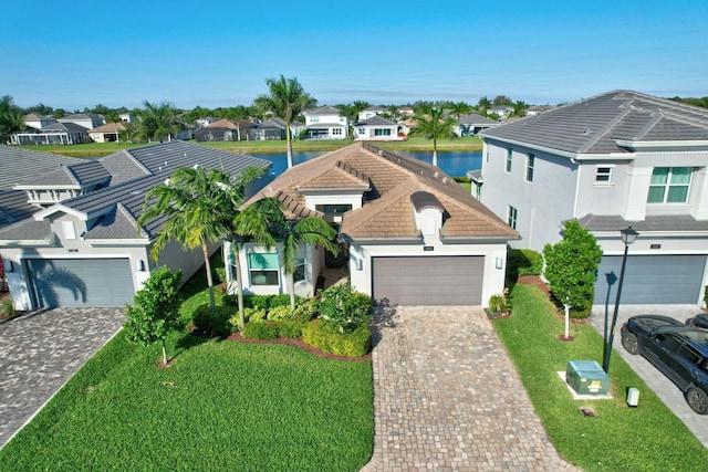 view of front of property with a residential view, stucco siding, driveway, an attached garage, and a front lawn