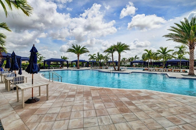 community pool with a gazebo and a patio area