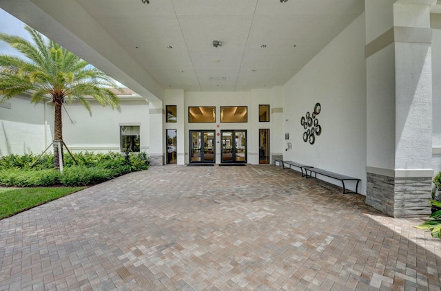 view of exterior entry with french doors, stone siding, and stucco siding