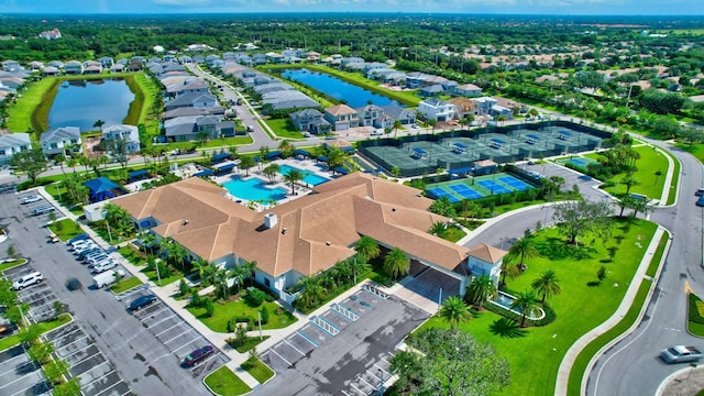 aerial view of residential area featuring a nearby body of water and a pool area