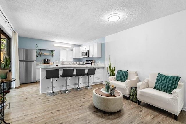 4059 Palm Bay Cir Unit C, West Palm Beach, FL 33406 - living area with a textured ceiling and light wood-style floors