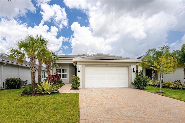 ranch-style house with decorative driveway, stucco siding, an attached garage, and a front lawn