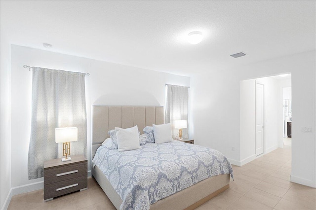 tiled bedroom featuring baseboards