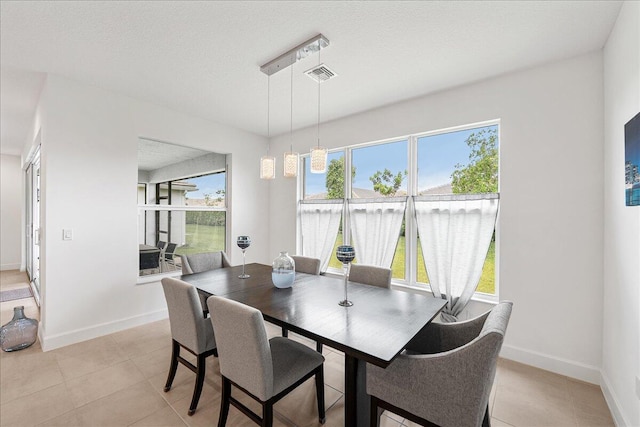 13339 SW River Rock Rd, Port Saint Lucie, FL 34987 - dining area featuring light tile patterned floors, baseboards, and a textured ceiling