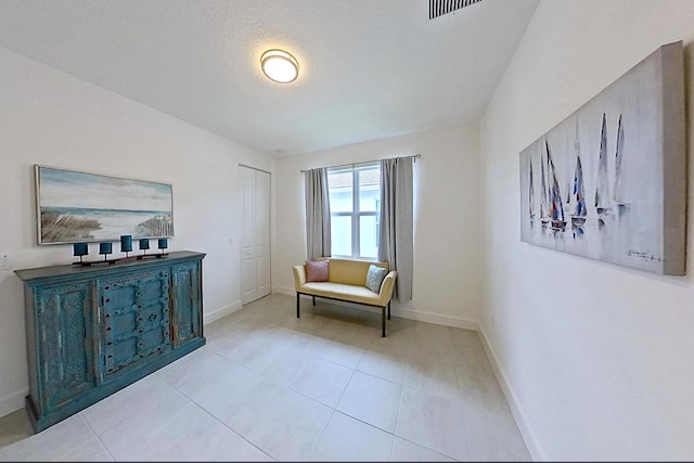 living area with baseboards and light tile patterned floors