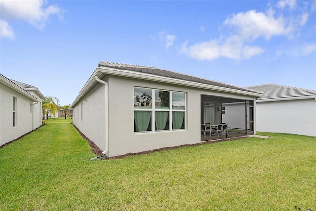 13339 SW River Rock Rd, Port Saint Lucie, FL 34987 - back of house featuring a lawn, stucco siding, and a sunroom