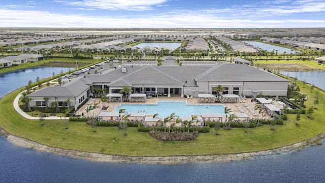 swimming pool with a water view, a residential view, and a lawn