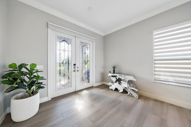 foyer entrance with french doors, ornamental molding, baseboards, and wood finished floors