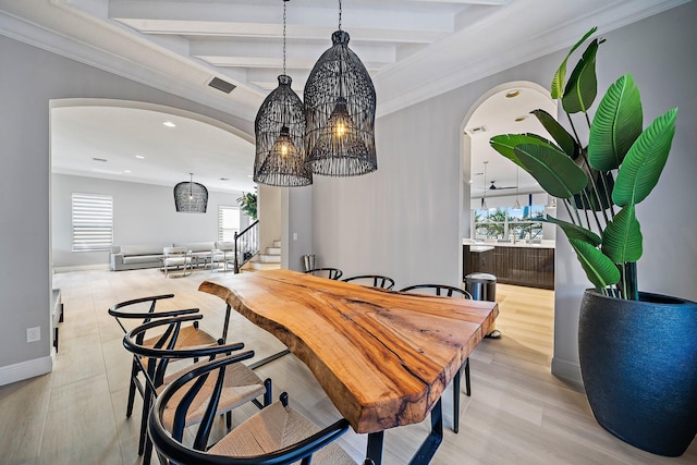 dining area featuring arched walkways, beam ceiling, recessed lighting, baseboards, and light wood-type flooring