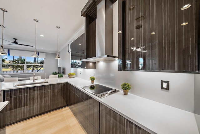 kitchen with wall chimney exhaust hood, electric cooktop, modern cabinets, a sink, and light countertops