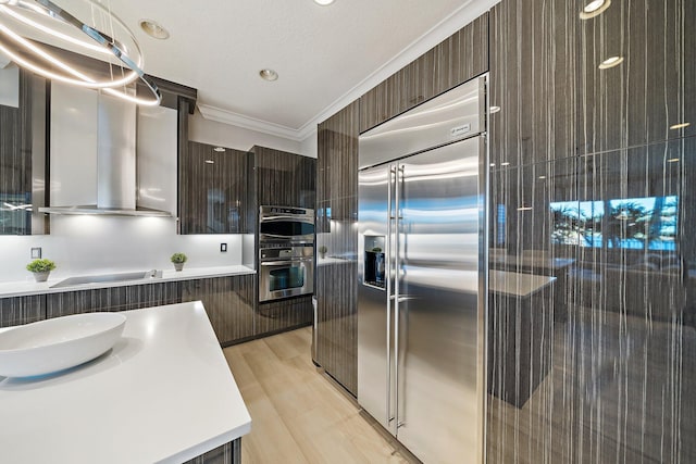kitchen with appliances with stainless steel finishes, modern cabinets, dark brown cabinets, ornamental molding, and light countertops