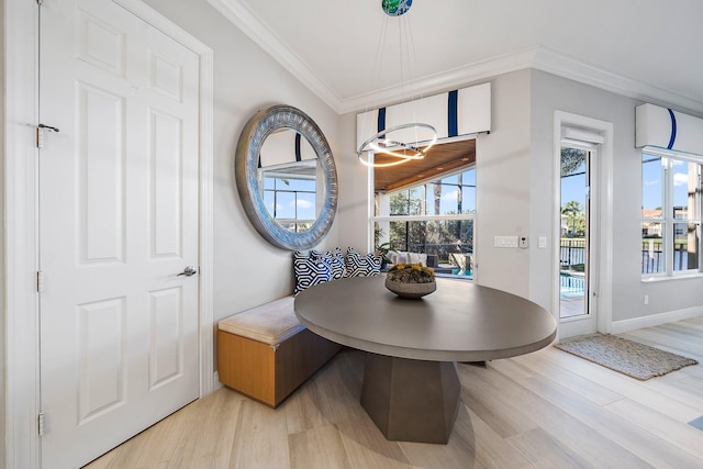 dining area featuring ornamental molding, light wood-style flooring, breakfast area, and baseboards
