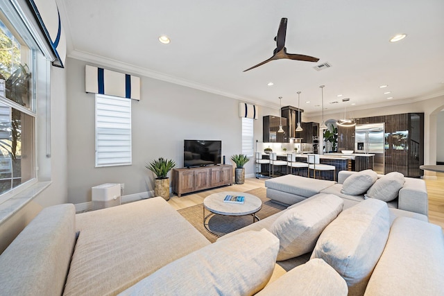 living room featuring ornamental molding, ceiling fan, recessed lighting, light wood-style floors, and baseboards