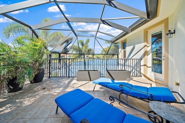 view of patio / terrace featuring a water view, an outdoor living space, and glass enclosure