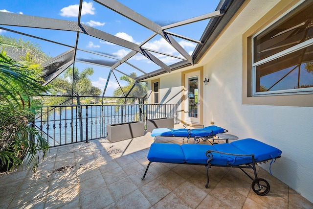 view of patio with a water view and glass enclosure