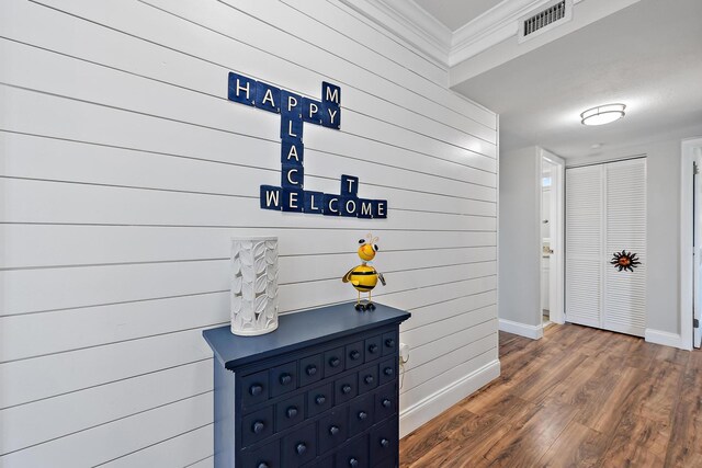 5393 SE Miles Grant Rd Unit A203, Stuart, FL 34997 - hallway featuring baseboards, wood walls, ornamental molding, and wood finished floors