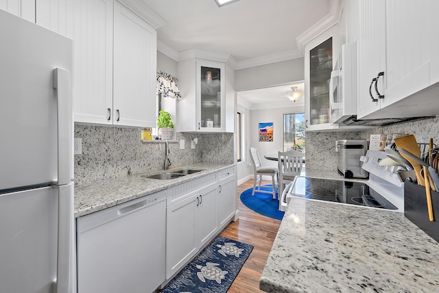 5393 SE Miles Grant Rd Unit A203, Stuart, FL 34997 - kitchen featuring white appliances, a sink, wood finished floors, crown molding, and backsplash