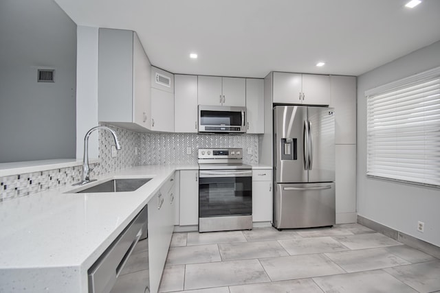 2201 Lucaya Bnd Unit K4, Coconut Creek, FL 33066 - kitchen with stainless steel appliances, a sink, decorative backsplash, baseboards, and recessed lighting